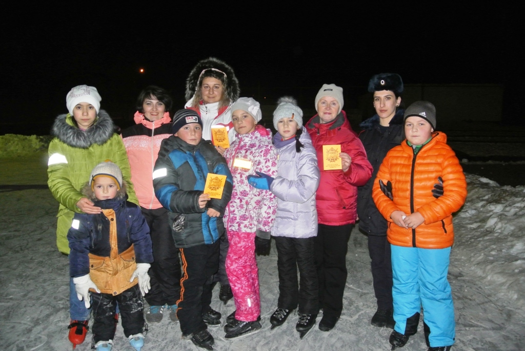 Посетители ледового катка на курорте Приэльбрусье изучают действие световозвращателей